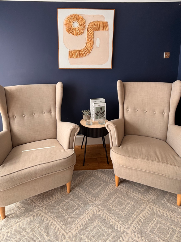 Therapy room with two light armchairs, soft lighting, and a welcoming atmosphere